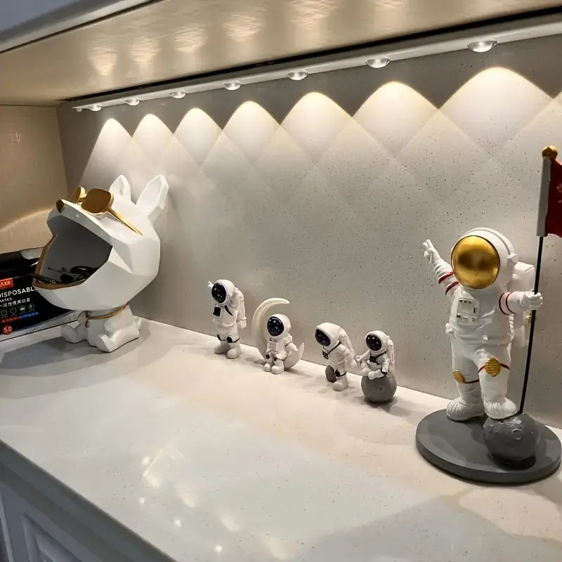 Collection of astronaut and space-themed figurines on a display shelf.