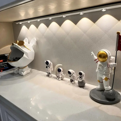 Collection of astronaut and space-themed figurines on a display shelf.