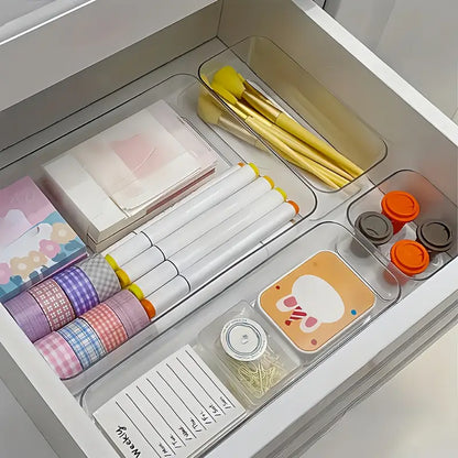 Organized desk drawer with stationery items including notebooks, pens, and washi tape.